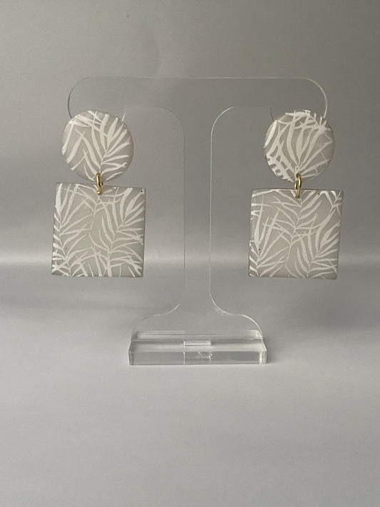 Neutral, translucent polymer clay earrings with white leaf print and gold edges.